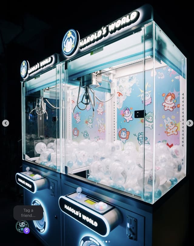 Two fully branded Harold's World claw machines with custom marquees, control panels, and interior backdrop art