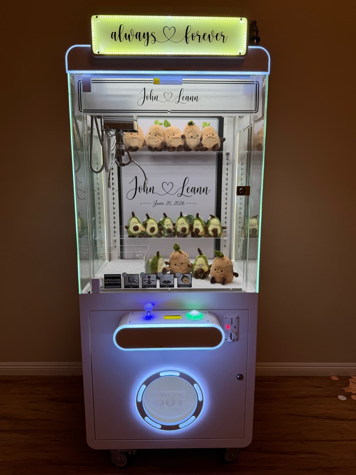 Claw machine glowing at a wedding reception with a personalized LED marquee sign