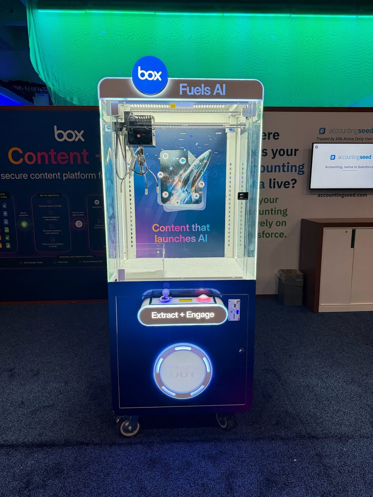 Box branded claw machine with Fuels AI marquee on a conference expo floor