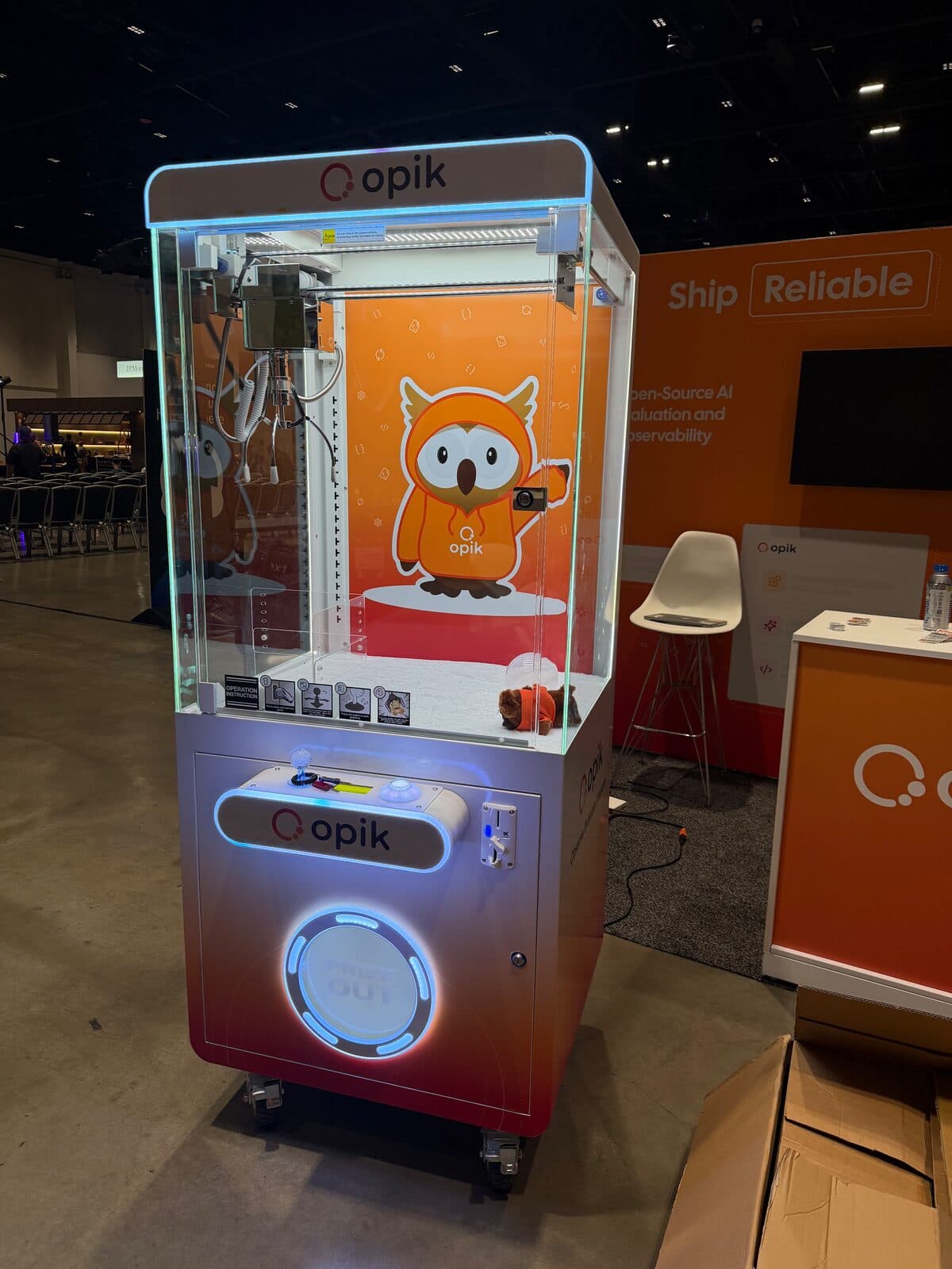 Comet Opik branded orange claw machine at WeAreDevelopers World Congress 2026 inside the San Jose McEnery Convention Center