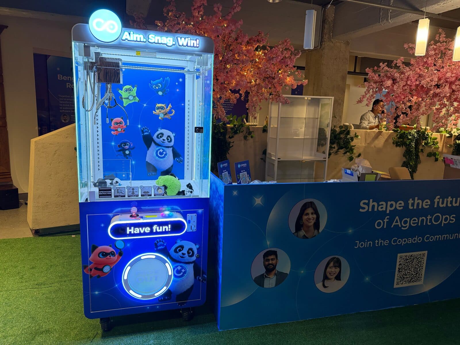 Copado branded claw machine next to the Copado booth at Dreamforce