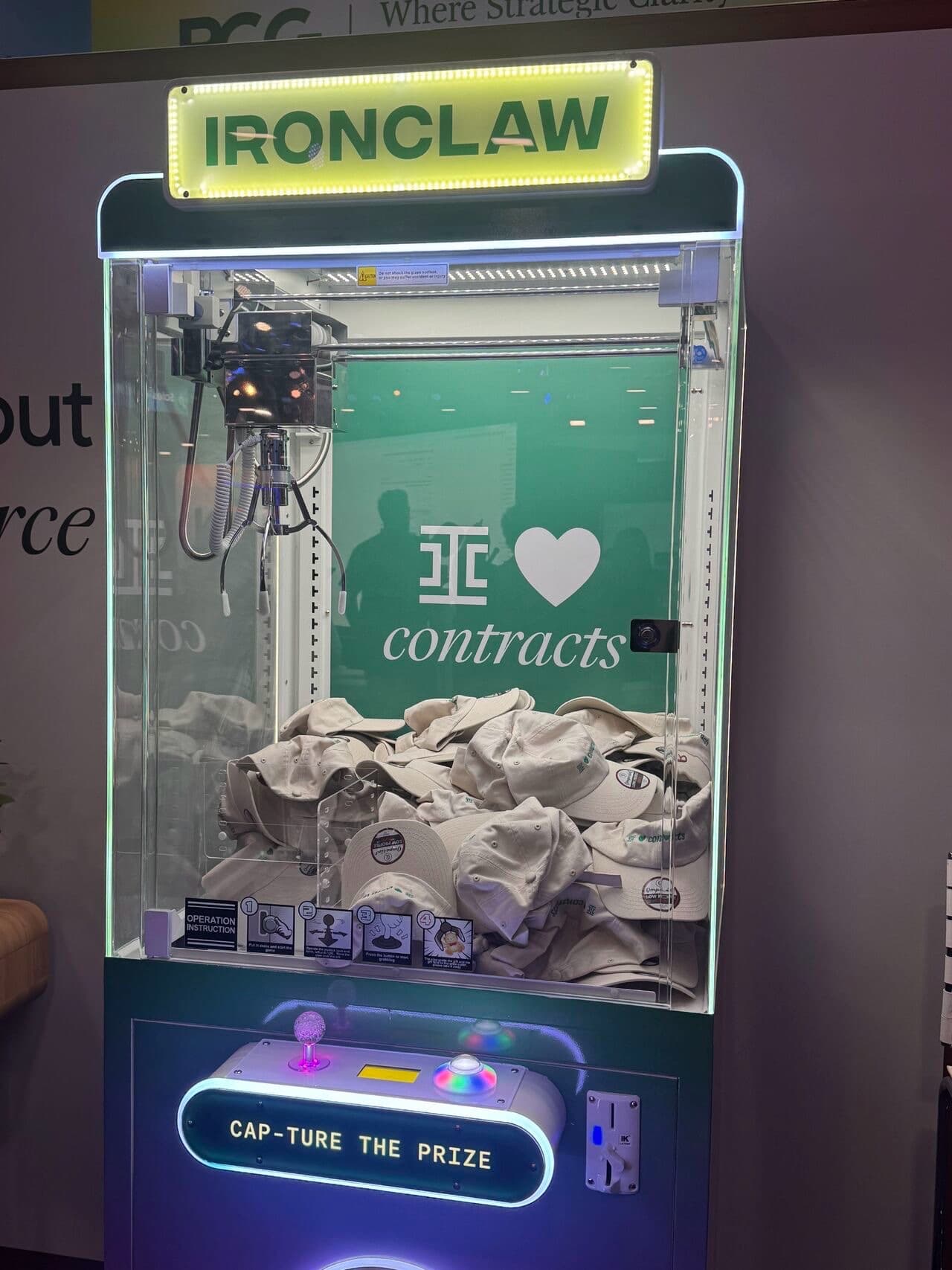 Ironclad branded claw machine with lit IRONCLAW marquee, Ironclad loves contracts backdrop, and Cap-ture the Prize control panel at Dreamforce 2026
