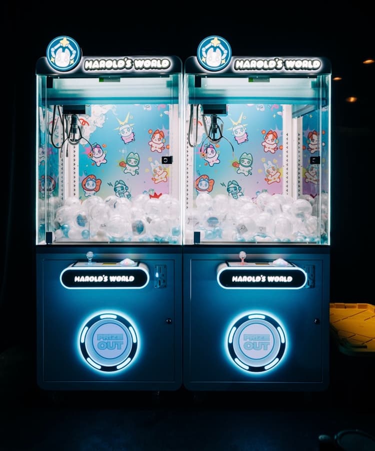 Two Harold's World branded claw machines with custom marquee, backdrop, and control panel branding